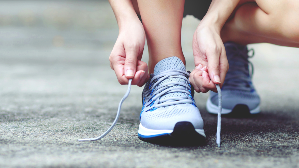 Closeup of hands tying laces on running shoes.