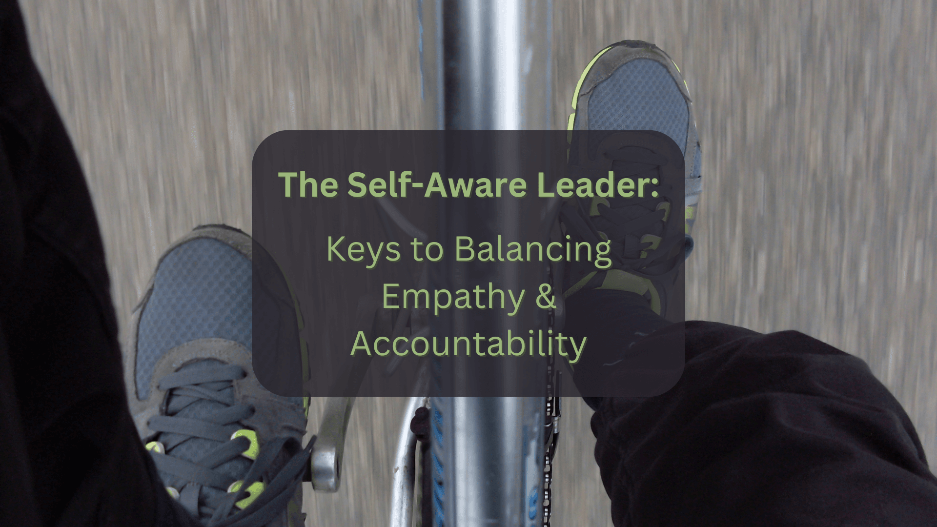 Looking down at feet pedaling a bicycle, symbolizing the delicate and deliberate act of putting pressure on two sides in rapid succession to achieve balance. Superimposed text reads The Self Aware Leader: Keys to Balancing Empathy & Accountability